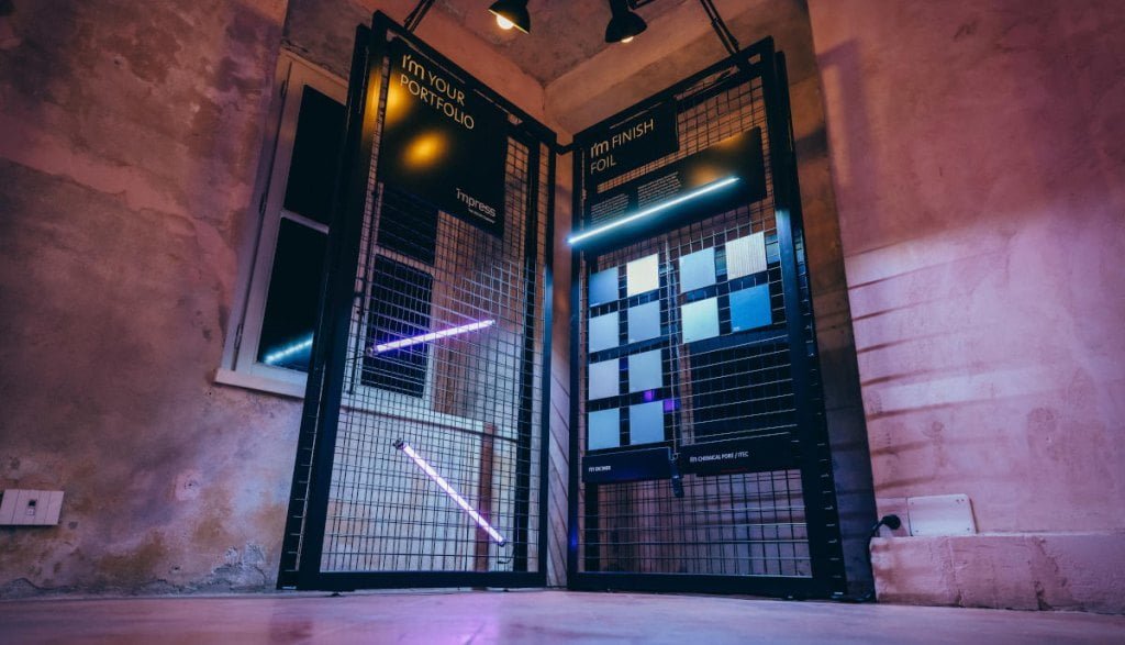 Ekspozytory z próbkami dekorów Impress Decor podczas tygodnia designu w Mediolanie.