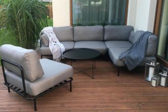 Zestaw mebli ogrodowych, sofa ogrodowa/narożnik i krzesło na drewnianym tarasie.
