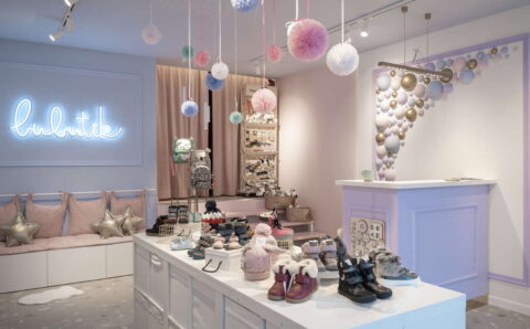 Aranżacja sklepu z obuwiem, projekt pracowni Fanajło Home Design Decor to ukłon w stronę dzieci. Na pierwszy plan wysuwają się kolorowe półkule na ścianie, które przywodzą na myśl bańki mydlane. Dopełnieniem kolorowej przestrzeni jest biel mebli potrzebnych do ekspozycji m.in. butów. Architektka Katarzyna Fanajło zadbała też o ukrycie pojemnego magazynu na buty za zasłoną. Kluczową rolę w sklepowej przestrzeni odgrywa jednak lada, która umożliwia wygodną obsługę. To miejsce, które powinno zostać dobrze doświetlone, dlatego w projekcie pojawiły się oprawy polskiej marki AQForm.