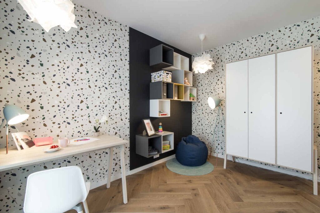 Dom szlachetnych barw, proj. KODO. Paleta w nieoczywisty sposób pozwoliła wykreować pomieszczenie unikalne i przyjazne dla dziecka. Meble są lekkie i jasne a fragmenty ścian oraz sprzętów ciemniejsze. Uwagę przykuwają tapety w zdecydowany wzór oraz ciemne zasłony. Przestrzeń ewoluuje wraz z rozwojem dziecka – jest łatwa w reorganizacji. 