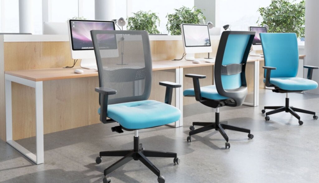 Otwarta przestrzeń biurowa open space, na pierwszym planie ergonomiczne krzesła biurowe.