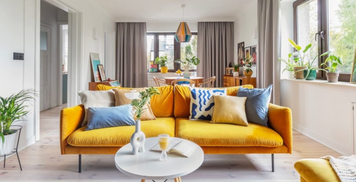 Projektantka Weronika Budzichowska zdecydowała, że nutę nowoczesności wprowadzi do salonu miodowa sofa z welurową tapicerką, a także techniczne lampy na suficie.