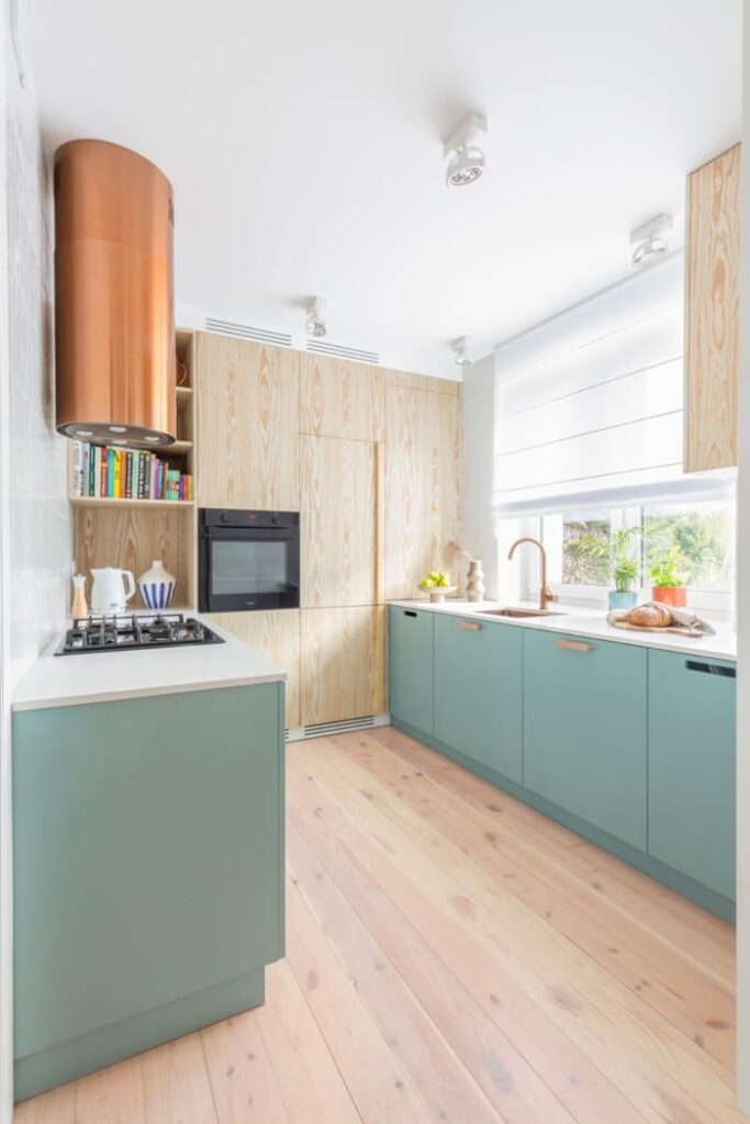 W kuchni projektantka Weronika Budzichowska z pracowni To Be Design postawiła na zabudowę z laminowanych płyt w kolorze jasnej zieleni.