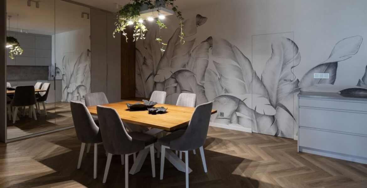 W centralnym miejscu otwartej przestrzeni kuchennej połączonej z jadalnią projektantka Agnieszka Lesiuk umieściła solidny drewniany stół, nad którym zawisła metalowa konstrukcja.