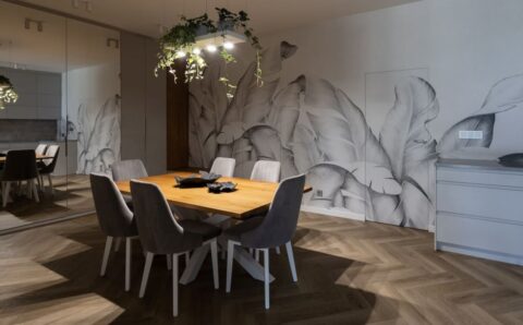 W centralnym miejscu otwartej przestrzeni kuchennej połączonej z jadalnią projektantka Agnieszka Lesiuk umieściła solidny drewniany stół, nad którym zawisła metalowa konstrukcja.