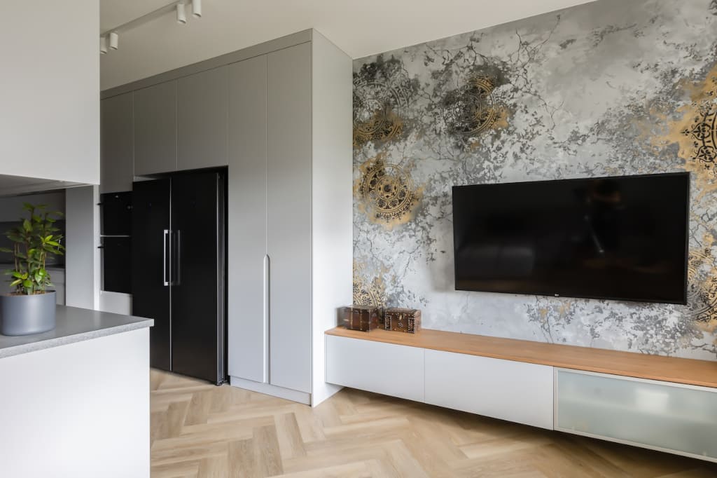 Ręcznie malowana mandala na ścianie za telewizorem to główną ozdobą salonu.