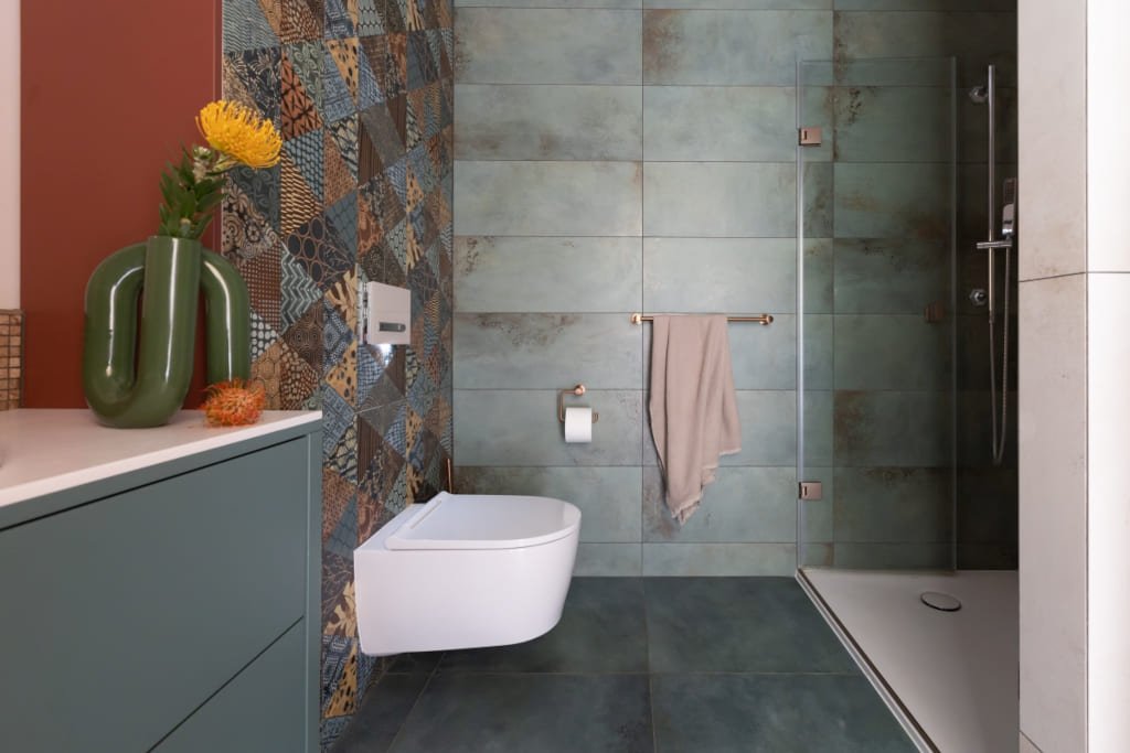 Jasne i zielone kolory znakomicie grają z dynamicznym, etnicznym dekorem na tylnej ściance WC. Proj. Kasia Orwat.
