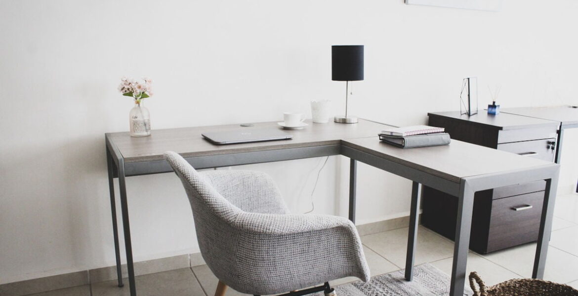 Home office utrzymany w tonacji szarej, krzesło i biurko do pracy.