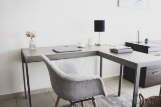 Home office utrzymany w tonacji szarej, krzesło i biurko do pracy.