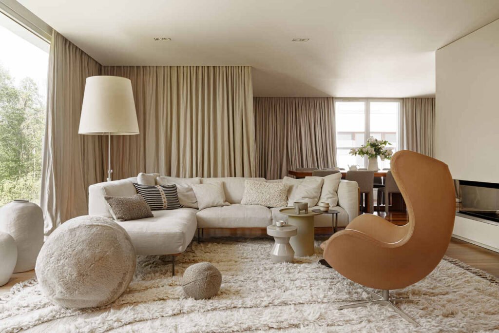 Wnętrze apartamentu o powierzchni 240 m2, wykończone w naturalnych materiałach, z grubymi lnianymi zasłonami w oknach, sofą Living Divani wykonaną u producenta w powierzonej tkaninie. Podłoga i stół z orzecha, krzesła filcowe Molteni oraz fotel z naturalnej rudej skóry.