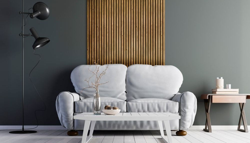 Lamele dekoracyjne ścienne w salonie, na pierwszym planie szara, wygodna kanapa.