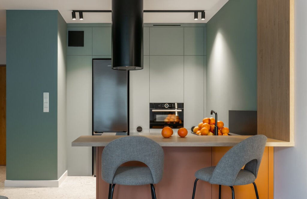 Kuchnia jest otwarta, oddzielona od salonu półwyspem, proj. KODO.