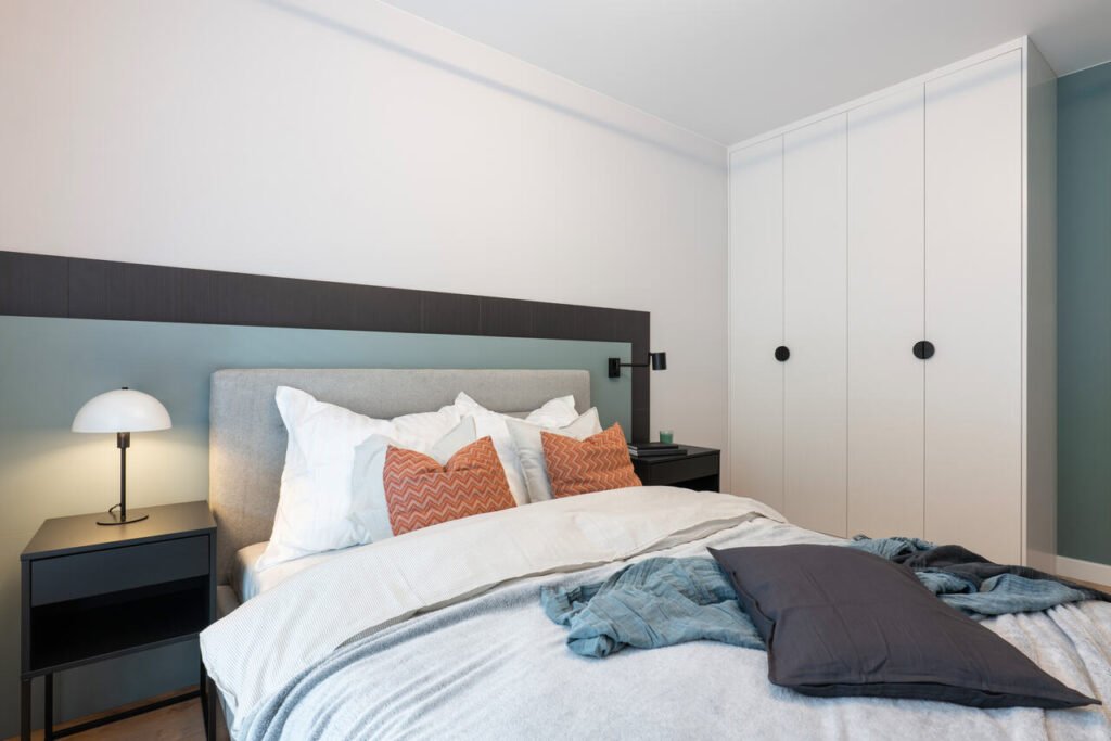 W sypialni pracownia KODO postawiła na stonowaną bazę kolorystyczną ożywioną akcentami – szarość, akwamaryna.
