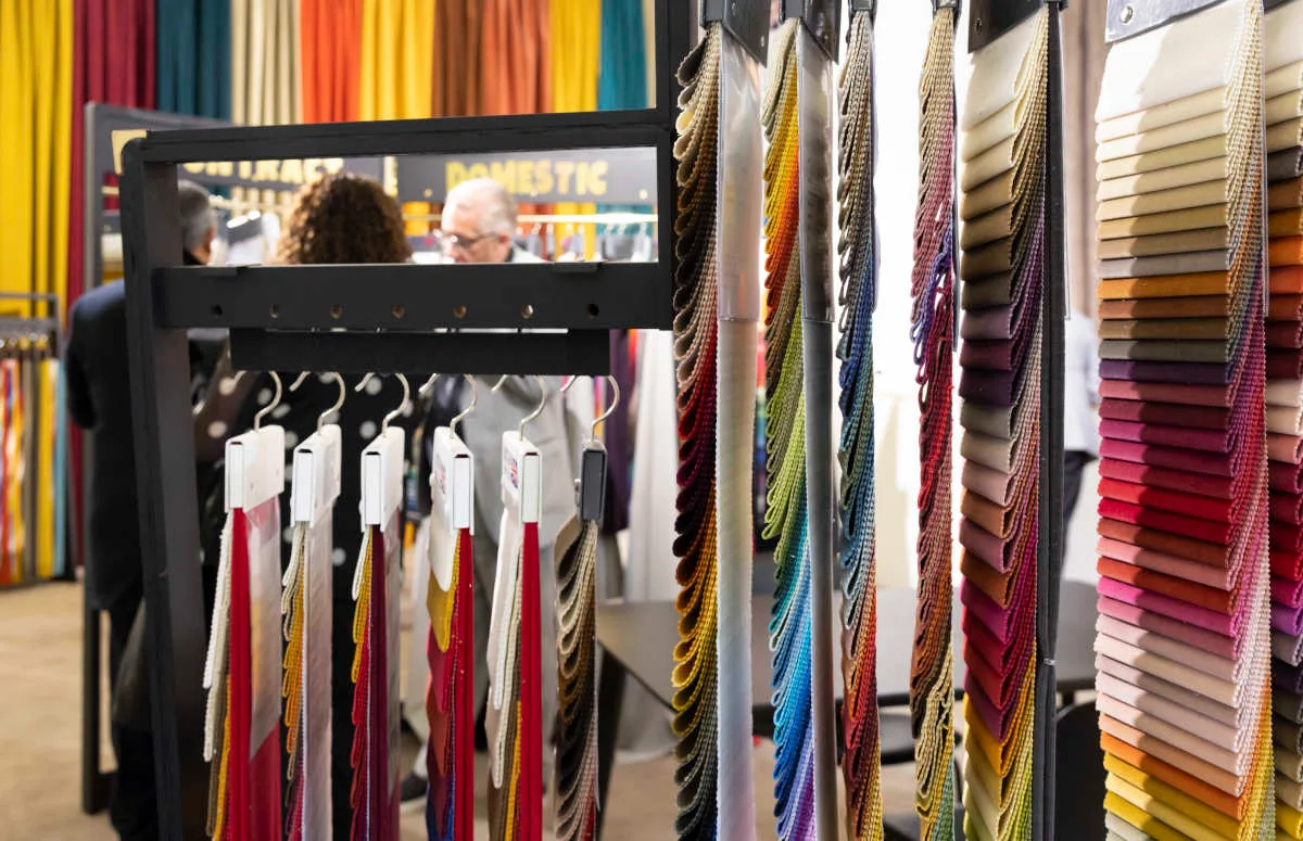 Tkaniny różnokolorowe na wieszakach na targach Heimtextil