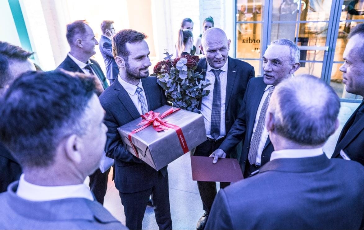 Przedstawiciele Schattdecor wręczają prezent Janowi Szynace podczas wydarzenia branżowego