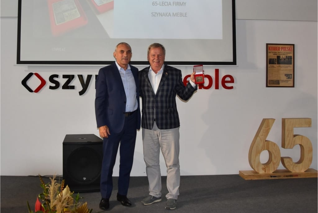 Jan Szynaka podczas targów Meble Polska w Poznaniu, w otoczeniu stoisk i odwiedzających