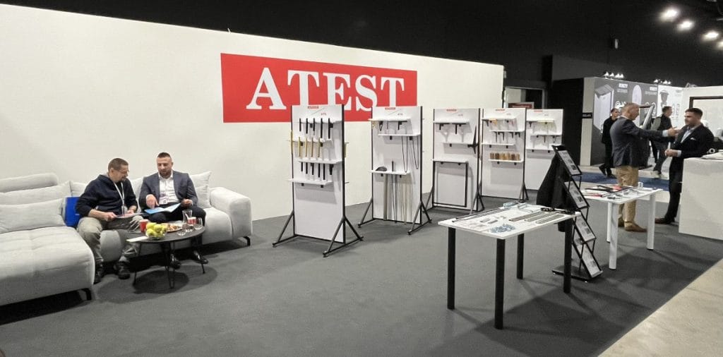 Stoisko ATEST i ATS z ekspozycją nóg meblowych, akcesoriów i rozwiązań meblowych podczas targów Warsaw Home 2024 w hali wystawowej.