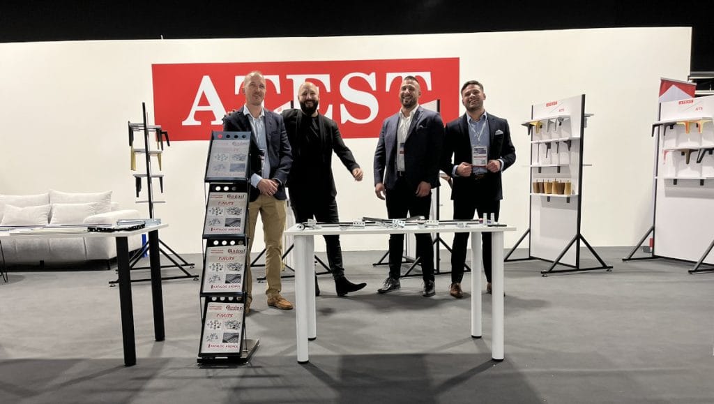 Ekipa firmy na stoisku ATEST i ATS z ekspozycją nóg meblowych, akcesoriów i rozwiązań meblowych podczas targów Warsaw Home 2024 w hali wystawowej.