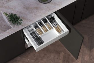 Wkład do szuflady kuchennej typu Ultra Box z organizerem na noże i sztućce, zamontowany w czarnej zabudowie kuchennej.