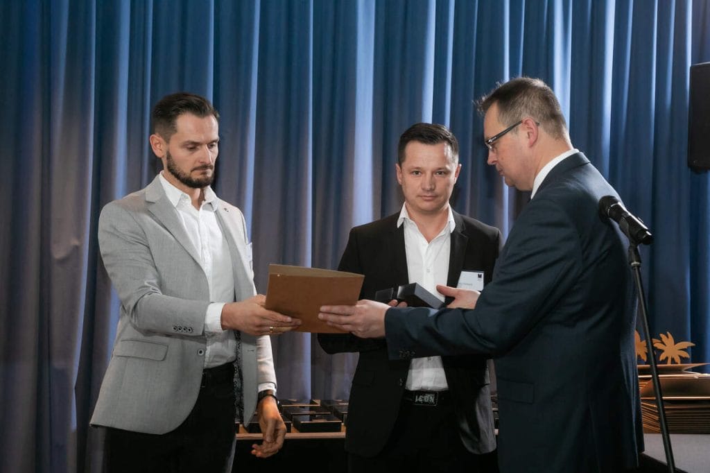 Od lewej: Sławomir Kaniewski i Robert Kaniewski odbierają z rąk Marka Hryniewickiego diament za kolekcję RAVELLO, prod. P.P.H.U. BRATTEX. Fot. Tomasz Markowski.