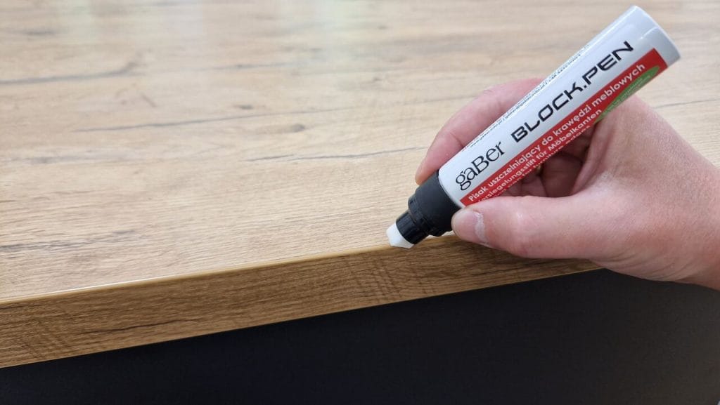 BLOCK.PEN to nowoczesny pisak przeznaczony do uszczelniania krawędzi meblowych, oferowany przez firmę Gaber. Produkt ten pozwala na szybkie i precyzyjne zabezpieczanie miejsc szczególnie narażonych na działanie wilgoci, takich jak połączenie obrzeża z blatem czy frontem meblowym. Dzięki swojej specjalnej formule zapewnia trwałą ochronę przed wodą, zapobiegając pęcznieniu oraz uszkodzeniom materiału. 
