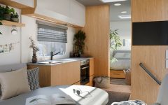 Wnętrze kampera z wykorzystaniem dekoru Interprint Rookwood Oak. Jasne drewno dębu wprowadza do mobilnych przestrzeni poczucie przytulności i nowoczesności, idealnie komponując się z szarościami i bielą.