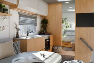 Wnętrze kampera z wykorzystaniem dekoru Interprint Rookwood Oak. Jasne drewno dębu wprowadza do mobilnych przestrzeni poczucie przytulności i nowoczesności, idealnie komponując się z szarościami i bielą.