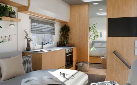 Wnętrze kampera z wykorzystaniem dekoru Interprint Rookwood Oak. Jasne drewno dębu wprowadza do mobilnych przestrzeni poczucie przytulności i nowoczesności, idealnie komponując się z szarościami i bielą.