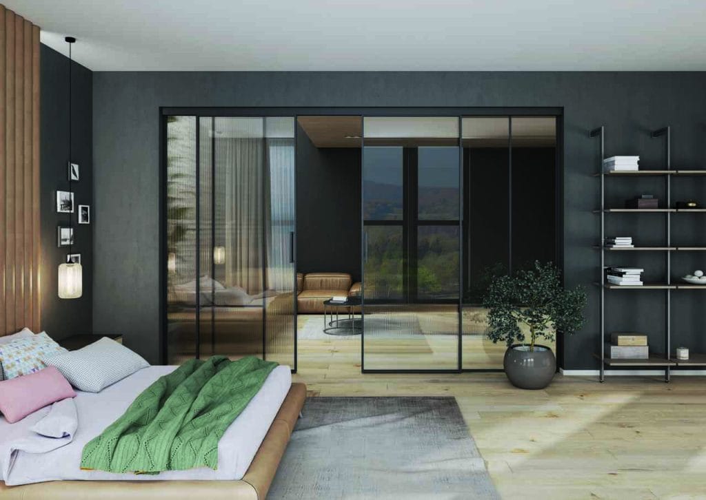 Przeszklenia Lumi firmy Komandor doskonale komponują się z przestrzenią snu, delikatnie oddzielając sypialnię od reszty mieszkania. Dzięki przezroczystym lub ryflowanym taflom, światło swobodnie przenika do wnętrza, tworząc przytulną atmosferę sprzyjającą relaksowi. Subtelne przepierzenie z podwieszanymi lub uchylnymi drzwiami, bez dolnych torów na podłodze, pozwala zachować poczucie intymności, nie zamykając przestrzeni, dzięki czemu sypialnia pozostaje lekka i harmonijna. 