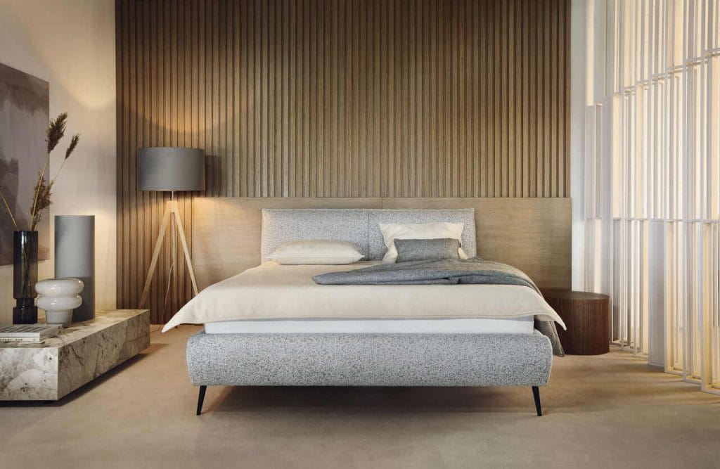 Przytulna sypialnia to jedno z najważniejszych miejsc w naszym domu. To tutaj codziennie odpoczywamy i regenerujemy siły po całym dniu. Centralnym elementem tej przestrzeni jest oczywiście łóżko. Wybierając odpowiedni model, powinniśmy zwrócić uwagę nie tylko na jego wygodę, ale także na design. Obecnie modne są łóżka na platformie, szczególnie te w jasnych, neutralnych kolorach tkanin. Lekka konstrukcja nie przytłacza przestrzeni, przez co doskonale komponuje się z nowoczesnymi aranżacjami. Łóżko ZOYA Fabryki Mebli Wersal, dzięki delikatnej formie należy do mebli, które przez długi czas będą doskonale wyglądać w każdym modernistycznymi wnętrzu. Obecność pojemnika na pościel pozwala przechowywać dodatkowy komplet pościeli. Cechą charakterystyczną tego modelu jest jego wezgłowie, które dzięki delikatnie nachylonej konstrukcji zapewnia komfortowe podparcie.