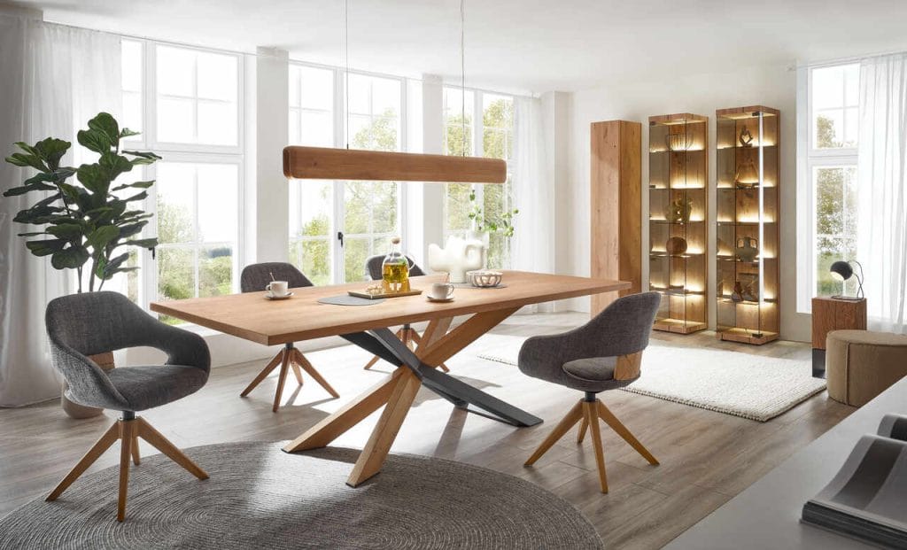 Stół do jadalni został wykonany z drewna dębowego. Jest otoczony wygodnymi tapicerowanymi krzesłami, których siedziska można obracać, a także lekko się na nich kołysać, aby zapewnić zdrowe siedzenie. Fot. Hartmann Möbelwerke.