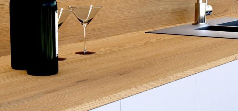 Blaty robocze FittLine to nowość w ofercie Kronospan. Wyprodukowane są na bazie surowych płyt wiórowych, pokrytych obustronnie dekoracyjnym laminatem HPL, wzmocnionych z przodu specjalnym paskiem z płyty HDF. FittLine to 18 mm w 5 odsłonach kolorystycznych – biały, czarny, biały kamień i 2 dekory drewnopodobne. 