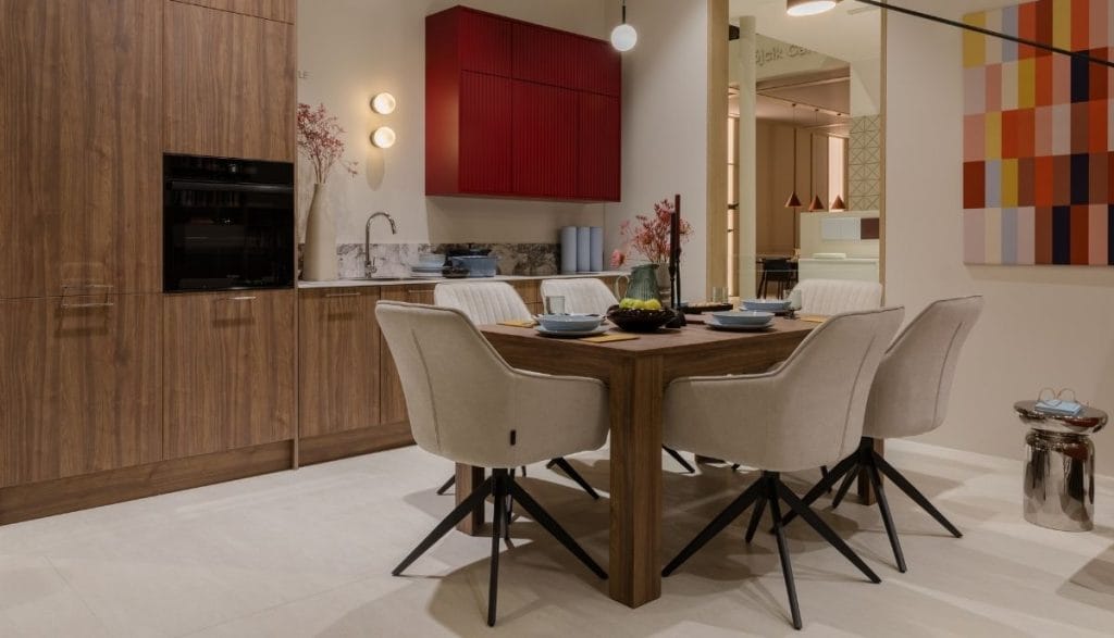 Aranżacja jadalni na Meble Polska 2026: nowoczesny stół z krzesłami na tle zabudowy kuchennej z czerwoną ryflowaną szafką z kolekcji Meble Wójcik 40 lat.