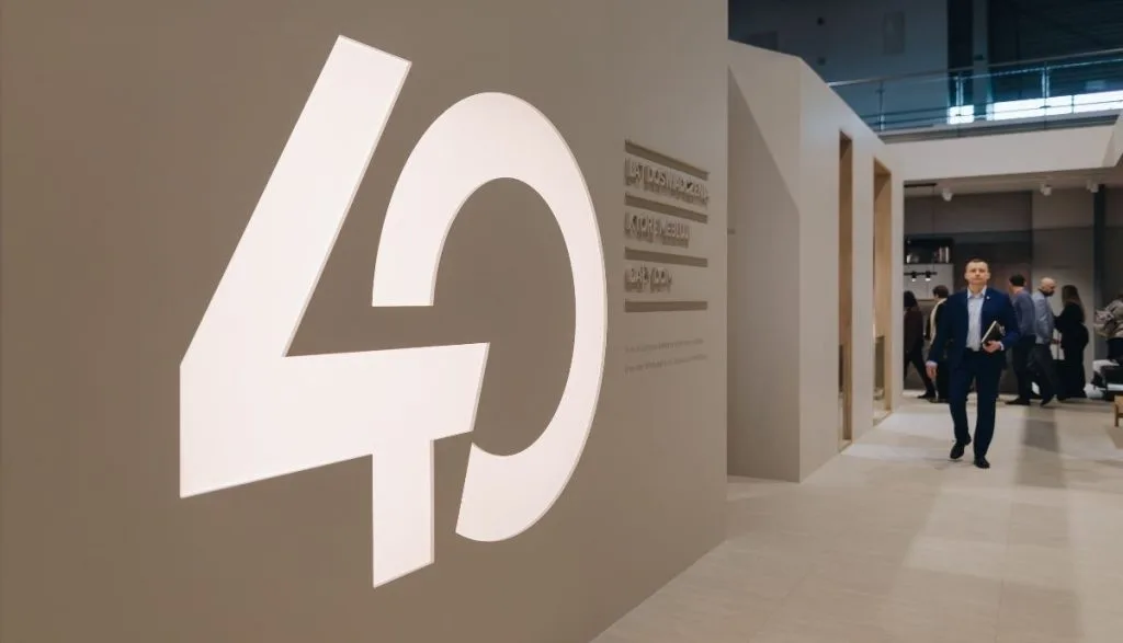 Zbliżenie na jubileuszową ściankę ekspozycyjną z podświetlanym logo „40” i hasłem o doświadczeniu na targach Meble Polska 2026 z okazji Meble Wójcik 40 lat.