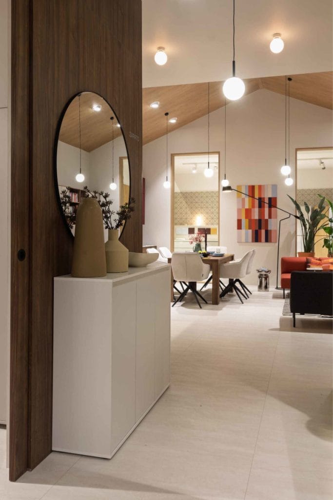 Designerska aranżacja strefy dziennej z okrągłym lustrem, otwierająca widok na dalszą część ekspozycji Meble Wójcik 40 lat na Meble Polska 2026.