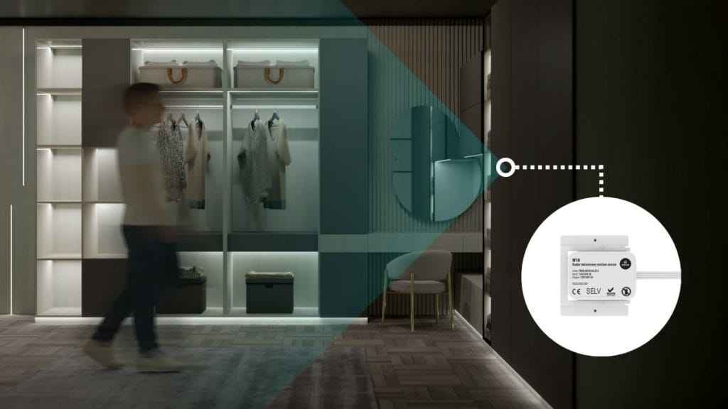 Widok na garderobę z szafami oświetlonymi chłodnym światłem LED. Rozmazana sylwetka mężczyzny idzie wzdłuż szaf, przechodząc przez zielonkawo-niebieską strefę światła. Po prawej stronie w białym kole widoczny jest schemat czujnika ruchu PIR z danymi technicznymi, połączony linią z krawędzią oświetlenia.