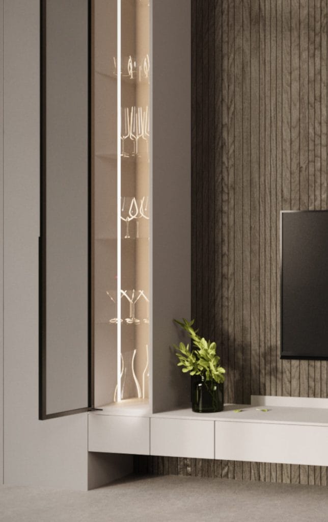Wysoka, wąska witryna meblowa z pionowym oświetleniem LED wewnątrz. Za szklanymi drzwiami w czarnej ramie widoczne są kieliszki. Obok szafka RTV na tle ściany wyłożonej pionowymi drewnianymi lamelami.