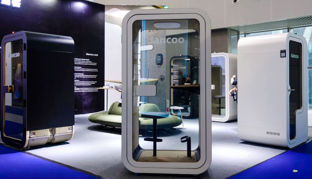 Ekspozycja marki Dancoo. Dancoo Smart Pods to inteligentne, modułowe przestrzenie, które zapewniają wygodę i prywatność w biurach oraz miejscach publicznych. Dzięki zastosowanej technologii, Smart Pods oferują optymalne warunki do pracy, odpoczynku i spotkań, tworząc elastyczne, wydzielone strefy w większych przestrzeniach.