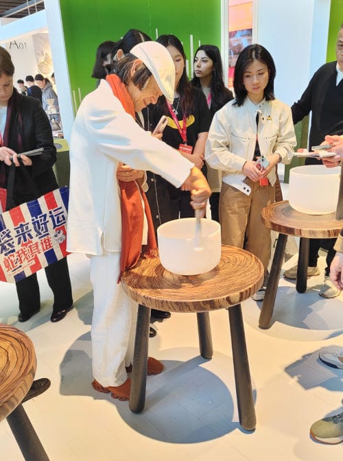 Zhu Xiaoji, kurator East Design Show 2025, podczas prezentacji tradycyjnej misy dźwiękowej. Elementy kultury i rzemiosła, takie jak misy wykorzystywane w kąpielach dźwiękowych, stały się częścią ekspozycji ukazującej dialog między dziedzictwem a współczesnym designem.