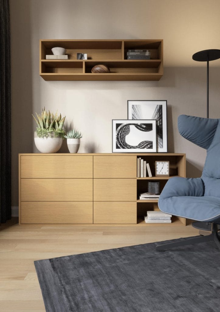 Niska komoda z otwartymi półkami wykonana w dekorze Arles Oak. Mebel zaprezentowany w nowoczesnym salonie z niebieskim fotelem i szarym dywanem.