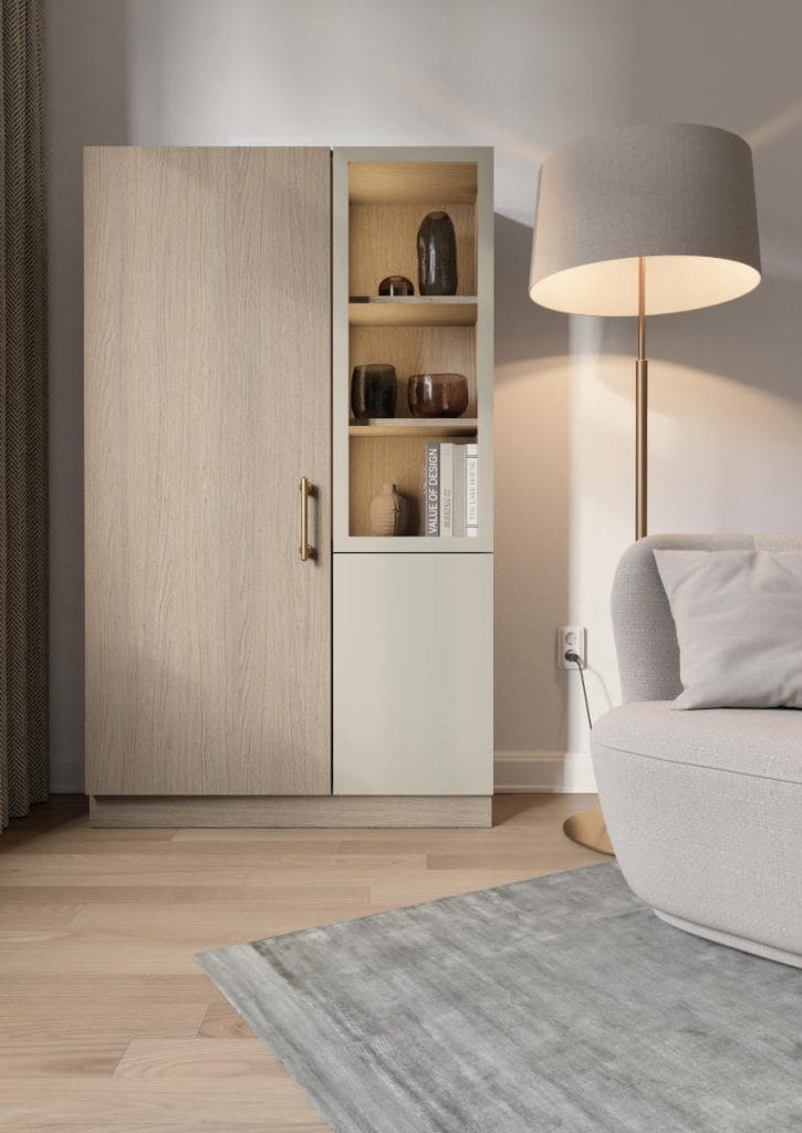 Dwudrzwiowa szafa z witryną łącząca dekor Arles Oak z beżowym frontem. Elegancki mebel salonowy przy jasnoszarej sofie.