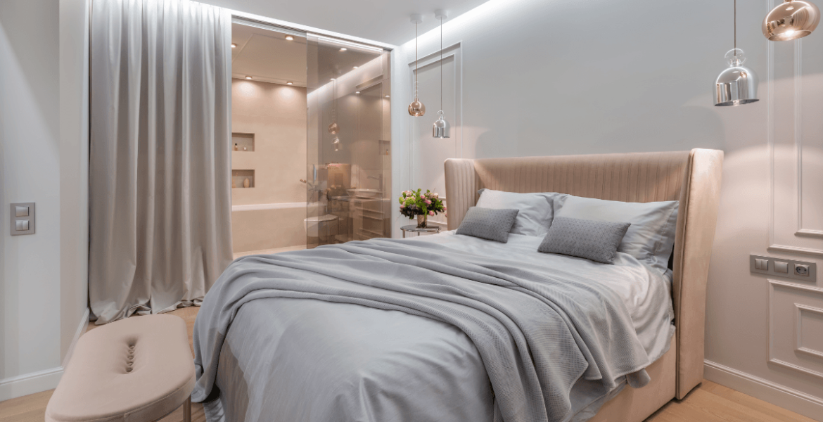 Luksusowe łózko z luksusowym materacem, sypialnia w tonach bieli i beżu.