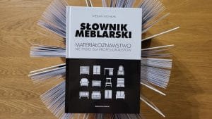 „Słownik meblarski. Materiałoznawstwo nie tylko dla profesjonalistów”, Słownik leżący na otwartych książkach.
