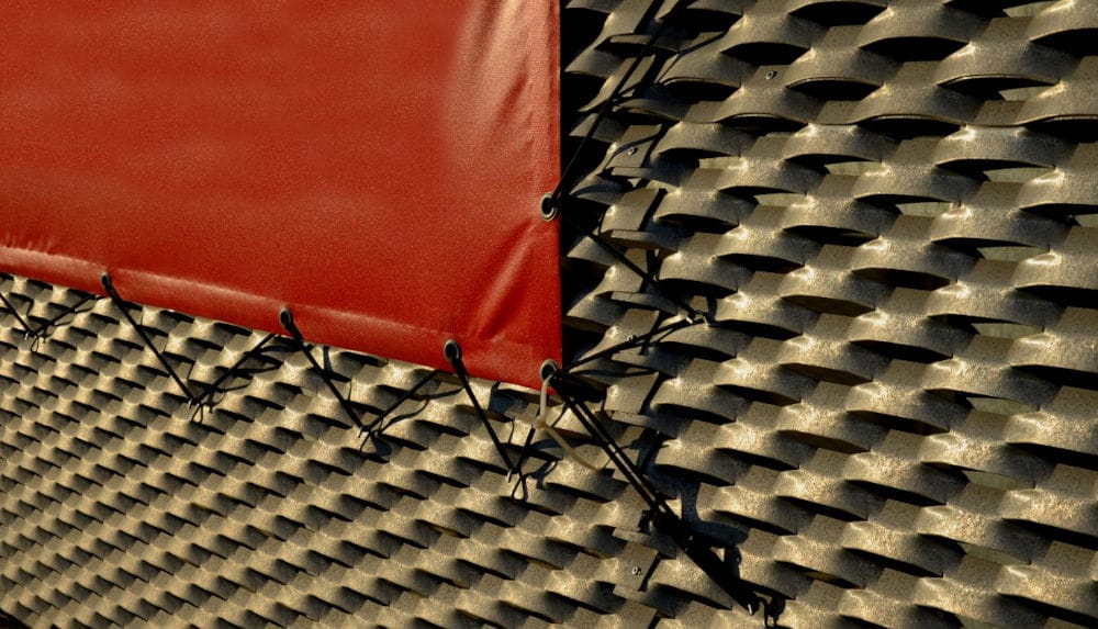 Fragment mebla ogrodowego z rattanu zakryty bordową plandeką.