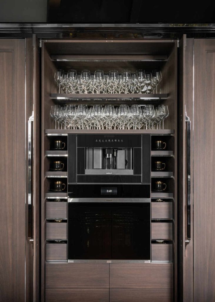 Wysokie szafki typu cargo lub z systemem wysuwanych półek to idealne rozwiązanie do przechowywania produktów spożywczych, butelek, słoików. Ułatwiają dostęp, pozwalają utrzymać porządek i eliminują potrzebę przeszukiwania tylnych rzędów. Warto zwrócić uwagę na nośność prowadnic i system cichego domyku – to detale, które robią różnicę. Kolejnym krokiem w stronę kuchni przyszłości są zintegrowane zabudowy AGD – piekarnik, ekspres, lodówka czy zmywarka dyskretnie wkomponowane w meble. Dzięki temu przestrzeń zyskuje jednolity charakter, a użytkownik – wygodę korzystania z urządzeń umieszczonych na ergonomicznej wysokości. Projekt mebli i wykonanie: Manufaktura Wirchomski. Fot. Ład Studio.