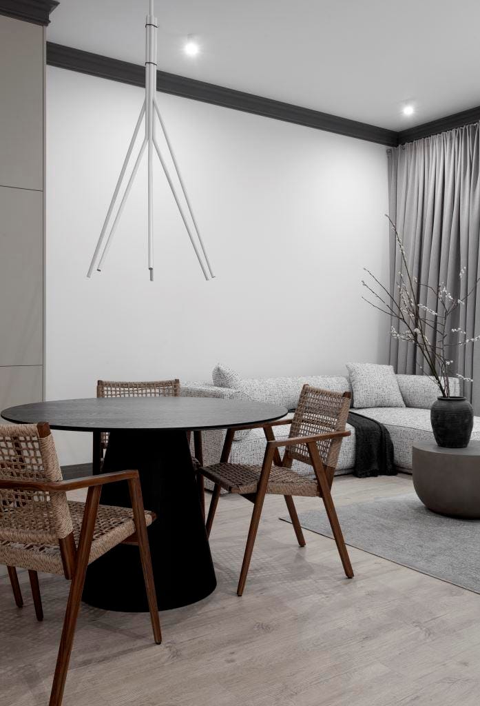 W prezentowanym, dość ascetycznym i monochromatycznym apartamencie czarny kolor wykorzystano jako zwieńczenie, ramy dla całej palety szarości definiujących i budujących projekt. Czarne listwy i gzymsy w wysokich (ponad 3 m) wnętrzach stały się charakterystycznym elementem tej przestrzeni. Spinają pomieszczenia w graficzne kompozycje uzupełnione pojedynczymi, czarnymi akcentami, jak stół, dekory czy fotel. Projekt arch. Anna Matuszewska-Janik, KREACJA PRZESTRZENI.