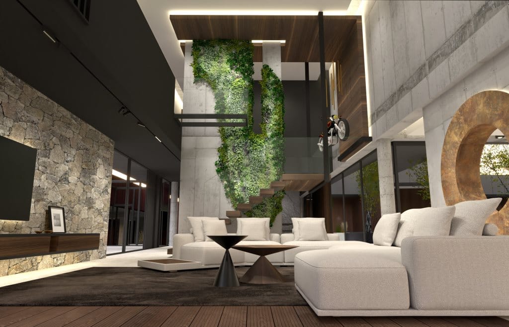 Rezydencja o powierzchni ok. 1,4 tys. m2, w okolicach Krakowa. Na wizualizacji: część dzienna – główny salon z widokiem na schody prowadzące na piętro. Za schodami znajduje się strefa wejścia, natomiast po prawej stronie – jadalnia i kuchnia oddzielone od salonu betonową ścianą z okrągłym otworem wykończonym miedzianą blachą. Beton, orzech amerykański i surowy, szary kamień uzupełniają detale z miedzi i akcenty czerni. Dominantą jest betonowa ściana, wokół której biegną wspornikowe schody z drewna orzechowego. Szkło balustrady na spoczniku załamuje się, tworząc dodatkowy podest, na którym wyeksponowano motocykl. To technologiczna rzeźba i manifest motoryzacyjnych pasji inwestora. Beton ściany porasta bujna, stabilizowana zieleń. Projekt: Michał Swałtek/Kaja Swałtek, Swałtek Design Studio.