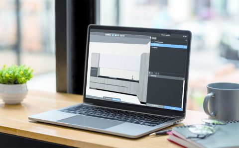 Laptop z oprogramowaniem Viyar Pro na drewnianym biurku obok kubka z kawą i okularów.