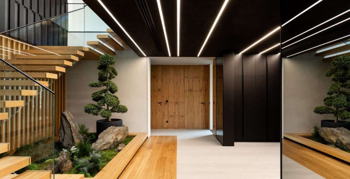 W luksusowych wnętrzach dwukondygnacyjnego domu spod kreski pracownia14, na szczególną uwagę zasługuje przestronny przedpokój z pomysłowo zaaranżowaną strefą zieleni pod schodami.