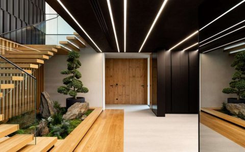 W luksusowych wnętrzach dwukondygnacyjnego domu spod kreski pracownia14, na szczególną uwagę zasługuje przestronny przedpokój z pomysłowo zaaranżowaną strefą zieleni pod schodami.